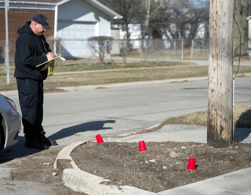 A Saginaw Police officer looks at possible evidence at the scene while investigating a fatal shooting on Saginaw's northeast side, Wednesday, April 2, 2014. A male was confirmed dead behind the house. Hundreds of people took to the streets of Saginaw as part of an anti-violence effort that began the same day as the fatal shooting in the city. Police Chief Brian Lipe told the crowd that officers were investigating the city's first gun-related homicide of 2014. That announcement brought boos from the crowd, which included police, firefighters, community leaders and youth group members. (AP Photo/The Saginaw News, Jeff Schrier) ALL LOCAL TV OUT; LOCAL TV INTERNET OUT