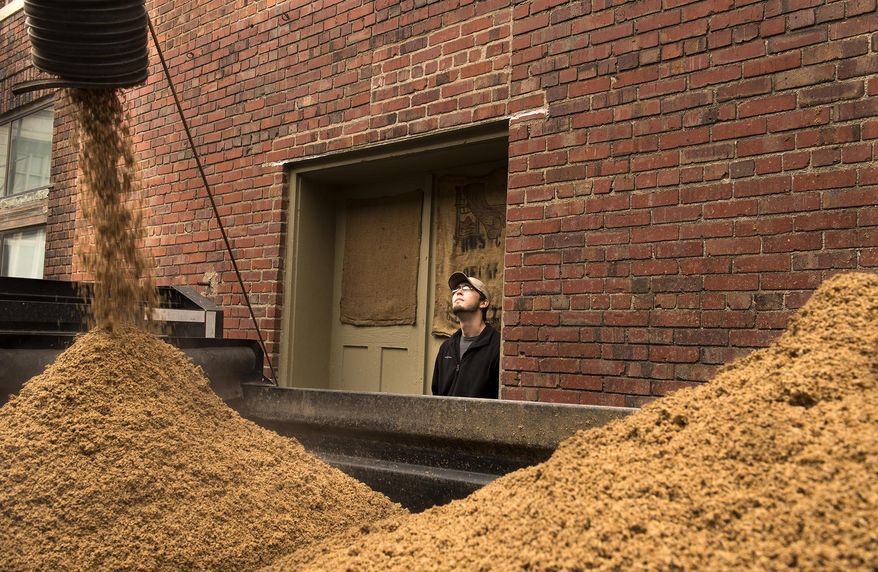 Calvin West, with Meyer Dairy Farm, watches as spent grain bound for the farm fills the trailer at Empyrean Brewing on Tuesday, April 1, 2014, in Lincoln. Breweries in Nebraska say a federal proposal would force them to stop giving spent grains to local farmers to use as cattle feed. Brewers and farmers say the practice is mutually beneficial. It gives farmers cheap and nutritious cattle feed and the breweries no longer have to pay to have the spent grains hauled to a landfill. (AP Photo/The Journal-Star, Gwyneth Roberts) LOCAL TV OUT; KOLN-TV OUT; KGIN-TV OUT; KLKN-TV OUT