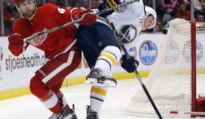 Detroit Red Wings' Jakub Kindl (4), of the Czech Republic, knocks Buffalo Sabres' Luke Adam (72) off-balance during the first period of an NHL hockey game Friday, April 4, 2014, in Detroit. (AP Photo/Duane Burleson)