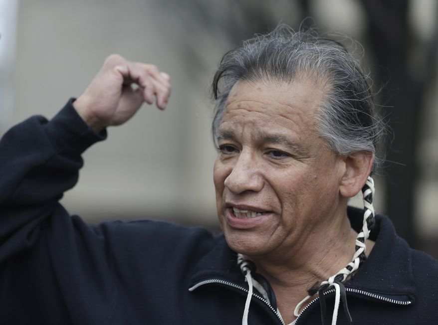 Robert Roche, an Apache Native American, says that Native Americans find the use of Chief Wahoo demeaning before a baseball game between the Minnesota Twins and the Cleveland Indians, Friday, April 4, 2014, in Cleveland. (AP Photo/Tony Dejak)