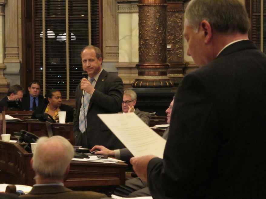 Kansas state Sen. Forrest Knox, standing, left, an Altoona Republican, discusses his proposal aimed at blocking schools from using Common Core standards for reading and math, with Sen. Jim Denning, right, an Overland Park Republican, Thursday, April 3, 2014, at the Statehouse in Topeka, Kan. Senators have added the proposal to a school funding plan. (AP Photo/John Hanna)