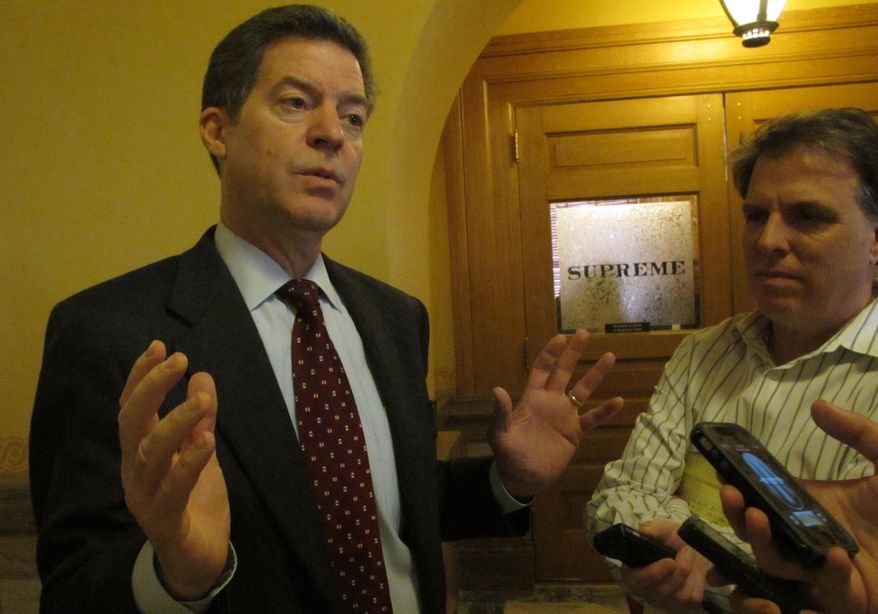 Kansas Gov. Sam Brownback answers questions from reporters about school funding issues, Friday, April 4, 2014, at the Statehouse in Topeka, Kan. Legislators are working on a plan for complying with a Kansas Supreme Court mandate to increase aid to poor school districts. (AP Photo/John Hanna)