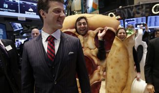 GrubHub Inc. CEO Matthew Maloney, trailed by costume characters, walks the New York Stock Exchange trading floor before his company&#x27;s IPO begins trading, Friday, April 4, 2014. Investors sent shares of the online food ordering service up 51 percent to $39.20 in early trading in its stock market debut Friday. (AP Photo/Richard Drew)