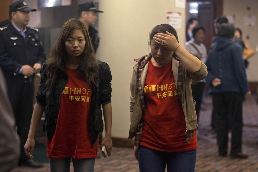 Relatives of the Chinese passengers onboard the Malaysia Airlines flight MH370 wear T-shirts with the words "Pray for MH370, safe return" in Beijing Thursday, April 3, 2014. No trace of the Boeing 777 has been found nearly a month after it vanished in the early hours of March 8 on a flight from Kuala Lumpur to Beijing with 239 people on board. (AP Photo/Ng Han Guan)