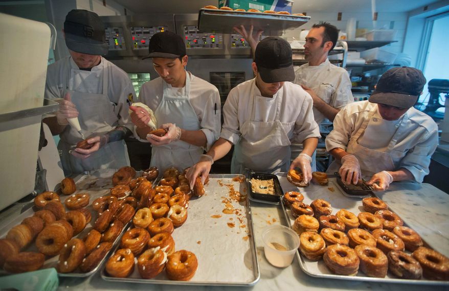 FILE- In this June 3, 2013 file photo, a baking crew makes Cronuts, a croissant-donut hybrid, at the Dominique Ansel Bakery in New York. Officials in New York City state that have closed the bakery dure to a severe mouse infestation. An NYC Department of Health spokeswoman says the rodent problem requires professional pest control but the bakery can reopen after inspectors determine the problem is fixed. (AP Photo/Richard Drew, File)