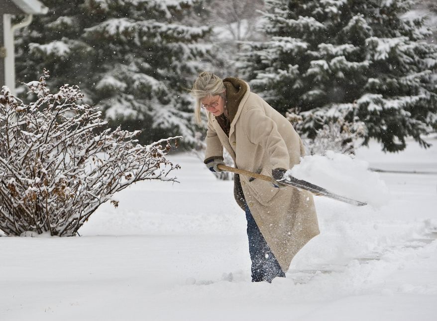 Norene McWilliams shovels her fathers walk in NW Rochester, Minn., early Friday, April 4, 2014. The National Weather Service has issued a winter storm warning for eastern and southern Minnesota until mid-morning. Another band of snow is expected to bring 1 to 2 inches of additional snow in the Twin Cities before it diminishes later Friday morning. (AP Photo/The Rochester Post-Bulletin, Jerry Olson)
