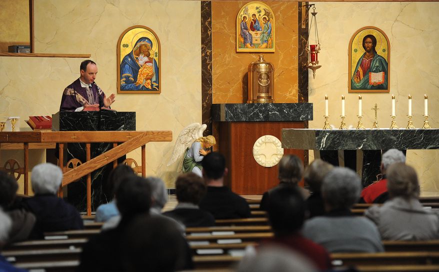 CORRECTS IDENTIFICATION FORM REV. JAMES MASON TO REV PAUL KING - Rev. Paul King conducts Mass at St. Lambert's Catholic Church in Sioux Falls, S.D. on Tuesday, April 1, 2014. The Roman Catholic Church, facing a decline in priests and changes in population, will merge several rural parishes in eastern South Dakota while creating a new one on the south side of Sioux Falls. (AP Photo/Argus Leader, Jay Pickthorn)