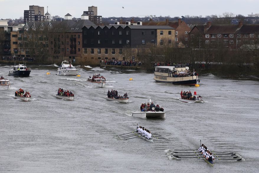 FILE - The Oxford University crew leads Cambridge University as they approach the finish line during the annual boat race on the Thames in southwest London in this Sunday, March 31, 2013 file photo.  Cambridge is holding a slight weight advantage in the annual Boat Race against Oxford on Sunday April 6, yet the Light Blues’ main asset might be an 18-year-old geography student with a juvenile face, weighing a little bit more than 53 kilograms. (AP Photo / Harry Hamburg, file)