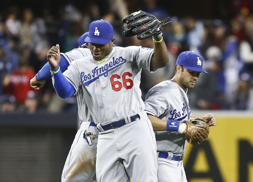 Los Angeles Dodgers' Yasiel Puig, center, Andre Ethier, right, and Carl Crawford do their bump celebration after the Dodgers' 3-2 victory over the San Diego Padres in a baseball game Tuesday, April 1, 2014, in San Diego. (AP Photo/Lenny Ignelzi)