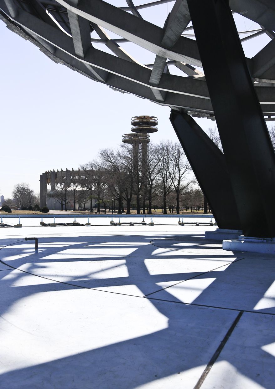 A space-age tower, left, is viewed near a giant metal globe called the Unisphere, structures remaining from the 1964 World's Fair, on Tuesday April 1, 2014 in the Queens borough of New York. As this month’s 50th anniversary of the 1964 New York World’s Fair approaches, a debate has emerged about what to do with some of the fair’s most famous structures. The towers topped by flying-saucer-like platforms, and a pavilion of pillars once called the “Tent of Tomorrow,” still sit as abandoned relics in the middle of Queens' Flushing Meadows Corona Park. (AP Photo/Bebeto Matthews)
