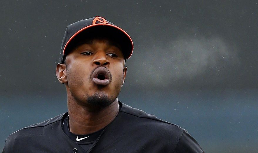Baltimore Orioles' Adam Jones breath is visible as he runs off the field against the Detroit Tigers in the second inning of a baseball game in Detroit, Friday, April 4, 2014. (AP Photo/Paul Sancya)
