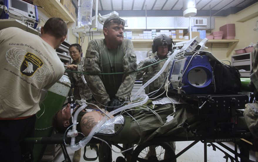 **FILE** Sgt. Al Smoot, of Harold, Calif., part of a U.S. Medevac team, gives CPR to a U.S. soldier in the emergency room of the U.S. military hospital at Bagram Air Base, north of Kabul, Afghanistan, on June 7, 2009. (Associated Press)