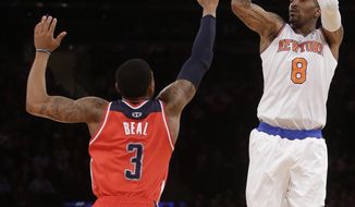 New York Knicks&#x27; J.R. Smith (8) shoots over Washington Wizards&#x27; John Wall (2) during the first half of an NBA basketball game Friday, April 4, 2014, in New York. (AP Photo/Frank Franklin II)