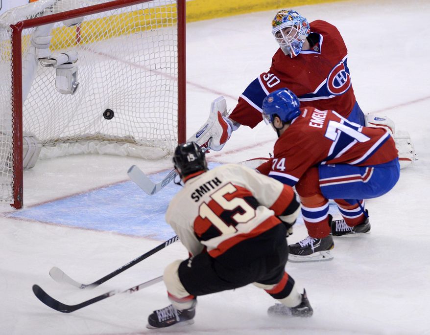 CORRECTS DATE TO FRIDAY APRIL 4 - Ottawa Senators forward Zack Smith (15) blasts the puck past Montreal Canadiens goalie Peter Budaj and defenseman Alexei Emelin during first period NHL hockey action in Ottawa on Friday, April 4, 2014. (AP Photo/The Canadian Press, Sean Kilpatrick)