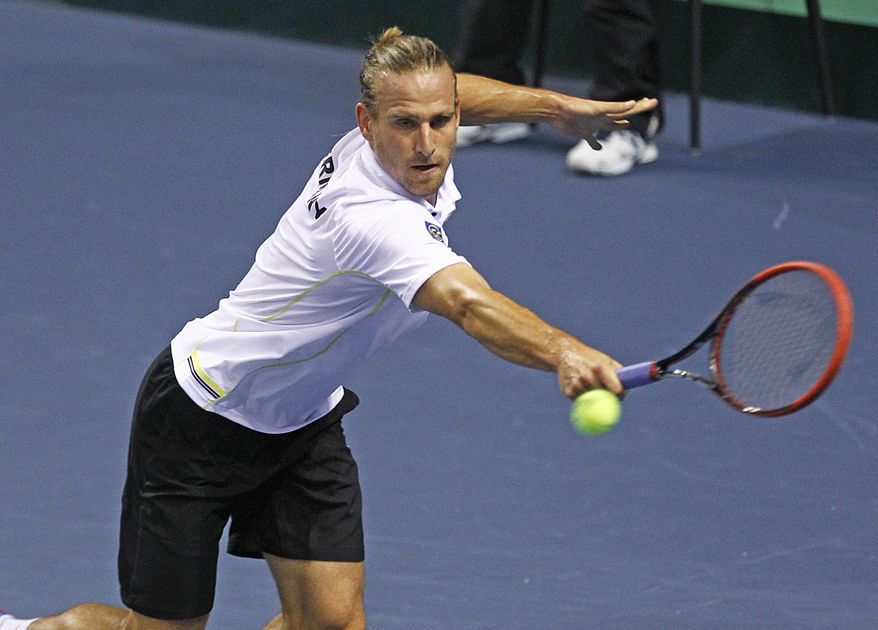 German tennis player Peter Gojowczyk returns the ball to French player Jo-Wifried Tsonga , during their single match in the quarterfinals of the Davis Cup in Nancy, eastern France, Friday, April 4, 2014. France plays against Germany from Friday, April 4 to Sunday April 6. (AP Photo/Remy de la Mauviniere)