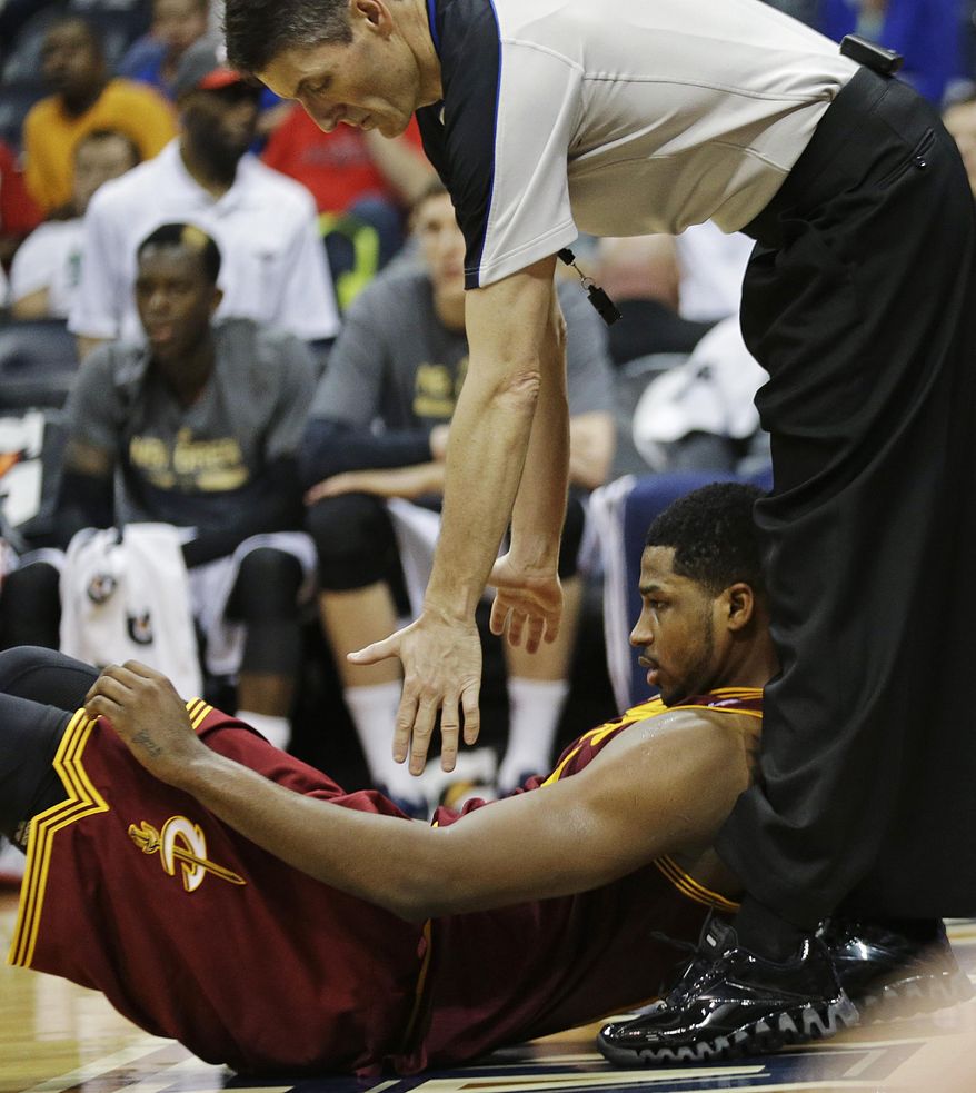 Cleveland Cavaliers' Tristan Thompson, bottom, falls at the feet of referee Scott Foster after a shot attempt in the fourth quarter of an NBA basketball game against the Atlanta Hawks, Friday, April 4, 2014, in Atlanta. The Hawks beat the Cavaliers 117-98. (AP Photo/David Goldman)