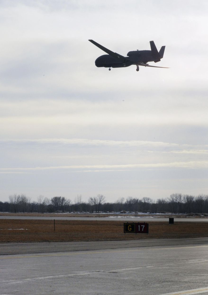 In this March 29, 2014 photo provided by the U.S. Air Force, an RQ-4 Global Hawk comes in to land at Grand Forks Air Force Base, N.D. The aircraft from the 348th Reconnaissance Squadron had just set a new record for longest flight by a military aircraft without air refueling, remaining aloft for 34.3 hours. It broke the record by a little more than an hour. Additionally, the mission was staffed entirely by female Airmen in recognition of Women's History Month. (AP Photo/Courtesy of the U.S. Air Force, Staff Sgt. David Dobrydney)