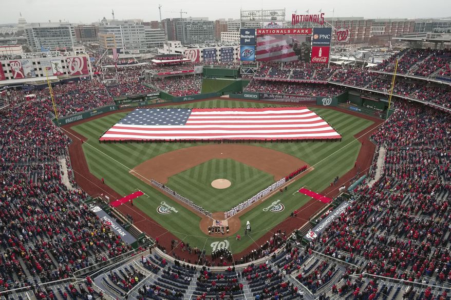 The United States Navy Ceremonial Guard stretches a large U.S. Flag across the field during the playing of the National Anthem before the baseball home opener between the Atlanta Braves and Washington Nationals at Nationals Park Friday, April 4, 2014, in Washington. (AP Photo/J. David Ake)
