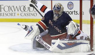 New York Rangers goalie Henrik Lundqvist (30), of Sweden, stops a shot on the goal by Ottawa Senators&#x27; Ales Hemsky (83) who flipped over him on the play during the first period of an NHL hockey game Saturday, April 5, 2014, in New York. (AP Photo/Frank Franklin II)