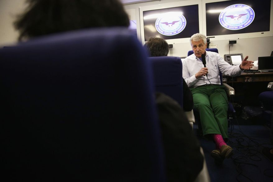 U.S. Defense Secretary Chuck Hagel speaks to members of a travel press pool, Friday, April 4, 2014, en route to Tokyo, from Honolulu. Hagel is en route to Japan, China and Mongolia. (AP Photo/Alex Wong, Pool)