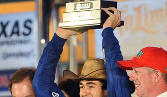 Chase Elliott holds up the trophy in Victory Lane after winning the NASCAR Nationwide Series auto race at Texas Motor Speedway in Fort Worth, Texas, Friday, April 4, 2014. (AP Photo/Ralph Lauer)