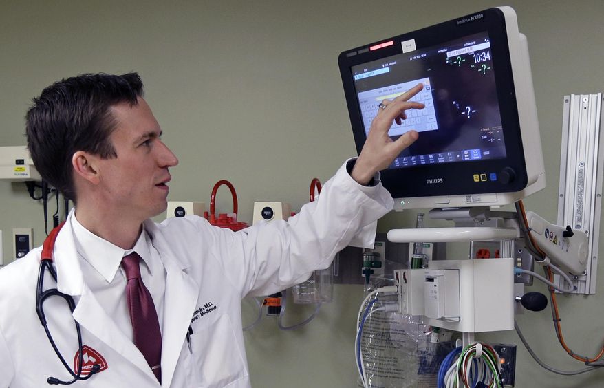 In this Tuesday, Feb. 11, 2014 photo, Dr. Marcus Romanello, medical director for the Fort Hamilton Hospital emergency room, checks equipment in the emergency room of the hospital in Hamilton, Ohio. The hospital saw 200 heroin overdose cases last year, and countless related problems: abscesses from using unsterile needles, heart-damaging endocarditis and potentially fatal sepsis infections. (AP Photo/Al Behrman)