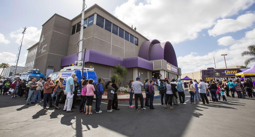 **FILE** Applicants line up outside the SEIU-UHW office during a health care enrollment event in Commerce, Calif., on March 31, 2014. (Associated Press)