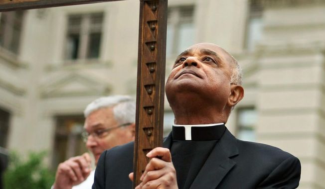 FILE - In this April 6, 2012, file photo, Rev. Wilton Gregory, the Archbishop of Atlanta holds a cross during the 32nd annual Good Friday Pilgrimage at Hurt Park in Atlanta. Gregory apologized Monday, March 31, 2014, for building a $2.2 million mansion for himself, a decision criticized by local Catholics who cited the example of austerity set by the new pope. (AP Photo/Atlanta Journal-Constitution, Jason Getz, File)