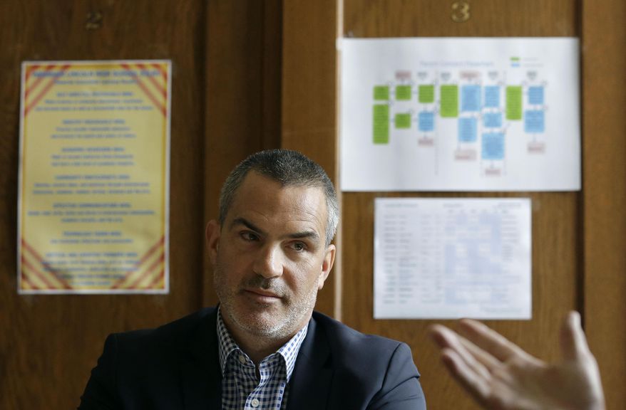 In this March 3, 2014 photo, Abraham Lincoln High School principal Barnaby Payne listens as Bill Sanderson, executive director at San Francisco Unified School District speaks in Payne's office in San Francisco. To be eligible for California’s public universities, high school students must complete 15 classes with a grade of C or better, including two years of foreign language, lab science, intermediate algebra, and visual or performing arts. Yet fewer than four of 10 do, fueling worries the state is facing a shortage of college-educated workers when the earning power a bachelor’s degree has never been higher. (AP Photo/Jeff Chiu)