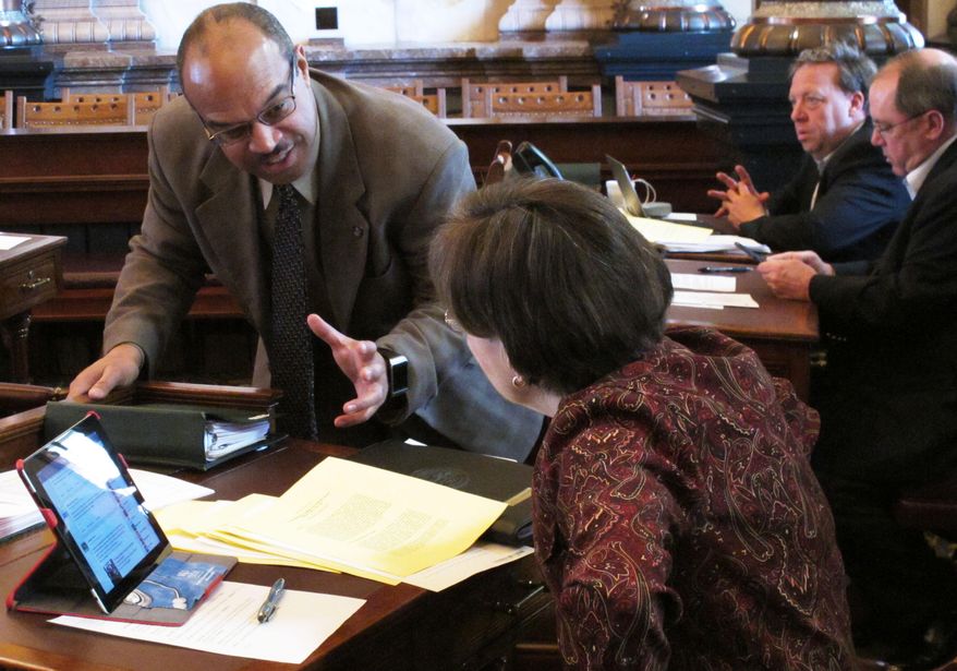 Democratic party Kansas state Sens. David Haley, left, of Kansas City, and Laura Kelly, right, of Topeka, confer during a Senate debate on a bill making technical changes in anti-abortion laws at the Statehouse in Topeka, Kan. on Saturday, April 5, 2014. Both opposed the measure, which passed and is going to Gov. Sam Brownback, a strong abortion opponent who has signed a raft of new restrictions on abortion and providers since taking office in January 2011. (AP Photo/John Hanna)