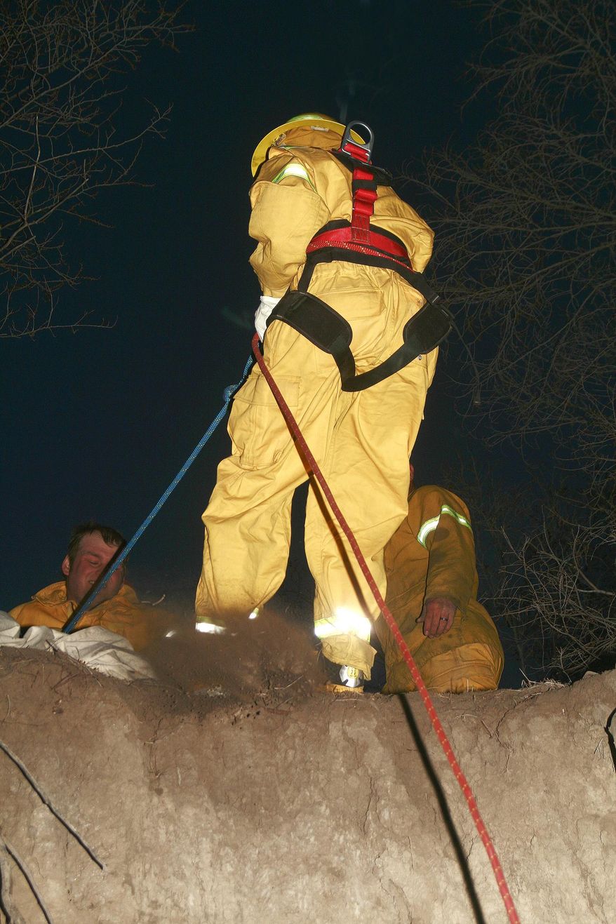 In this photo taken March 26, 2014, McCook, Nebraska, High School student Keith Helm, a member of the Red Willow Western Rural Fire Department’s new junior program, learns to trust his fellow firefighters as he acquires rope rescue and rappelling skills on a cliff at the fire barn Wednesday, March 26, 2014. Thirteen teens have joined the program and are learning how to fight fires and the skills that accompany and complement firefighting. (AP Photo/Daily Gazette, Connie Jo Discoe)