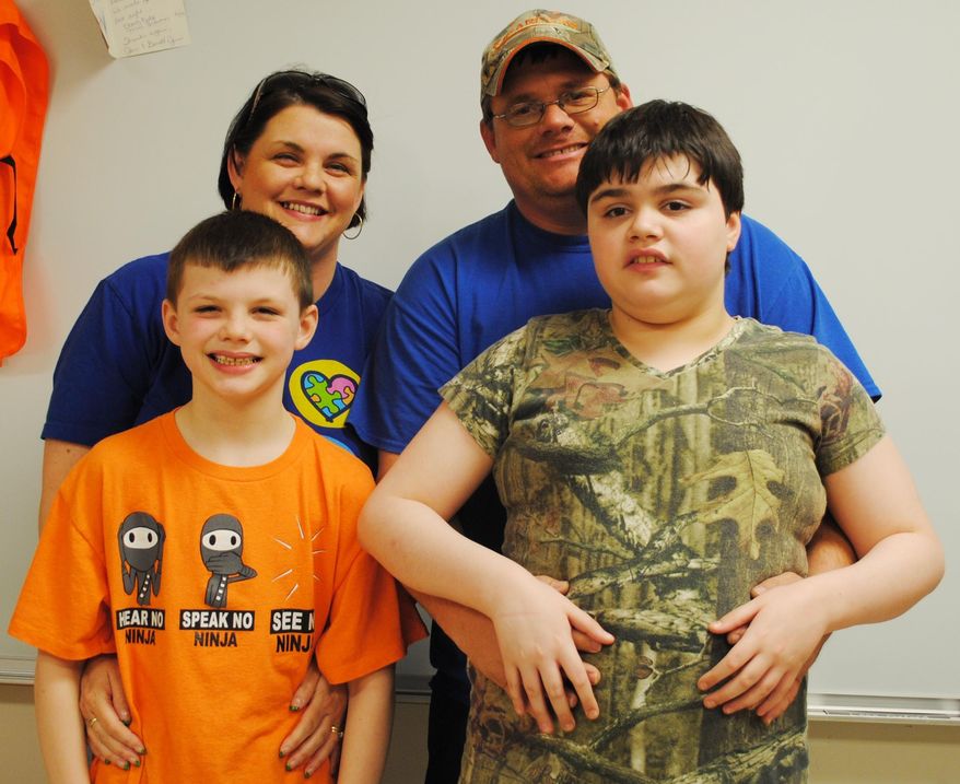 ADVANCE FOR USE SUNDAY, APRIL 6, 2014 - In this photo taken on March 20, 2014, Ginnie Rudi, rear left, and her husband Eric pose for a photo with their kids Austen, front left, and Lexi at Greene County Tech Primary School in Paragould, Ark. The Rudis have been open about sharing their story about their 12-year-old autistic daughter, Lexi, in order to raise awareness about the disorder. (AP Photo/The Paragould Daily Press, Rachel Simpson)