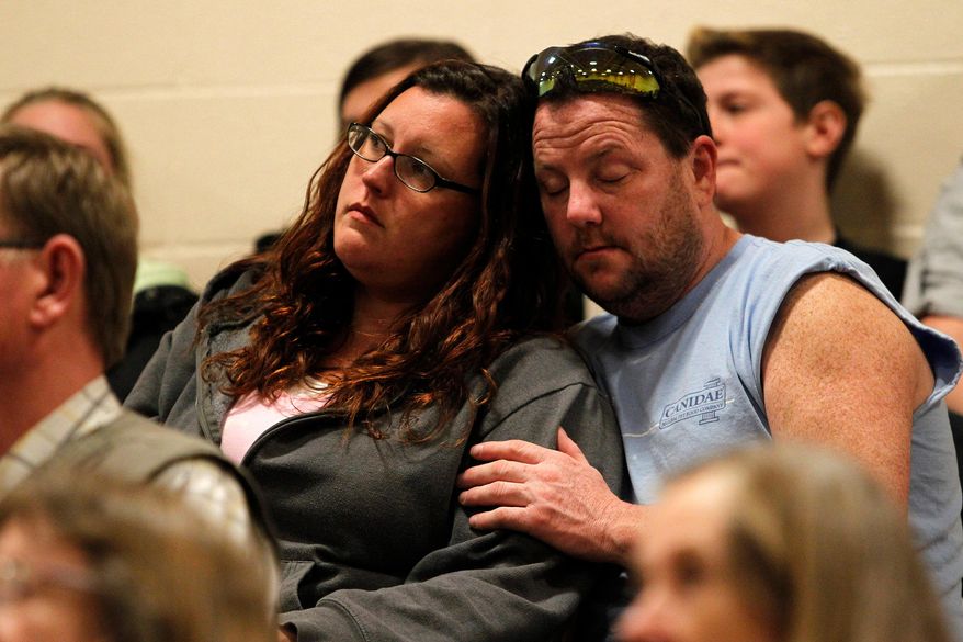 A couple listens to a speaker during a prayer service for those affected by the Oso mudslide, Friday night in Arlington, Wash. at Haller Middle School, Friday April 4, 2014. The Arlington Ministerial Association, a collective of over 30 churches, hosted the event. (AP Photo/POOL, Genna Martin)