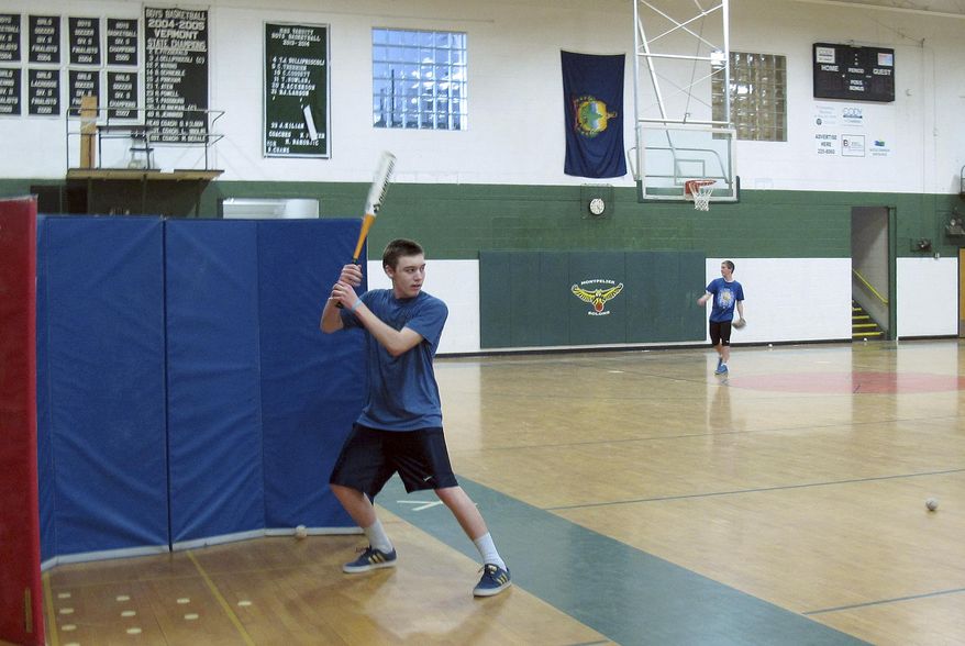 In this April 3, 2014 photo, baseball player Michael Roach takes batting practice in the Montpelier High School gym in Montpelier, Vt. Though the calendar says it's spring, the long-lasting winter has kept many Vermont spring sports teams from venturing outside. (AP Photo/Wilson Ring)