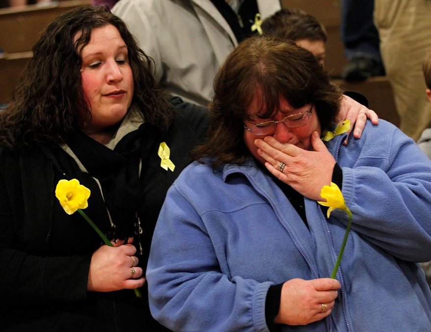 A woman becomes emotional during a prayer service at Haller Middle School in Arlington on Friday, April 4, 2014. The Arlington Ministerial Association, a collective of over 30 churches, hosted the event. (AP Photo/POOL, Genna Martin)