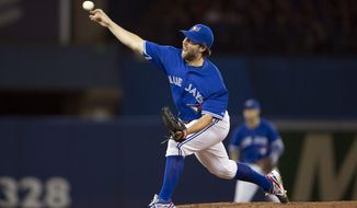Toronto Blue Jays starting pitcher R.A. Dickey delivers a pitch during the fourth inning of a baseball game against the New York Yankees in Toronto on Saturday, April 5, 2014. (AP Photo/The Canadian Press, Peter Power)