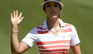 Michelle Wie waves after a birdie on the first hole during the third round of the Kraft Nabisco Championship golf tournament Saturday, April 5, 2014, in Rancho Mirage, Calif. (AP Photo/Chris Carlson)
