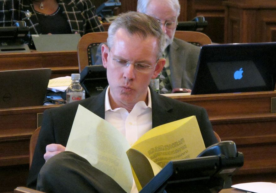 Kansas House Minority Leader Paul Davis, a Lawrence Democrat, reviews an explanation of a bill stripping cities and counties of their power to regulate guns, Saturday, April 5, 2014, at the Statehouse in Topeka, Kan. The House approved the legislation, 102-19, on Saturday, a day after the Senate passed it, 37-2. The measure goes next to Republican Gov. Sam Brownback. (AP Photo/John Hanna)