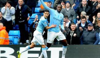 Manchester City&#x27;s Yaya Toure, right, celebrates with teammate Jesus Navas after scoring from the penalty spot against Southampton during the English Premier League soccer match between Manchester City and Southampton at The Etihad Stadium, Manchester, England, Saturday, April  5, 2014.  (AP Photo/Rui Vieira)