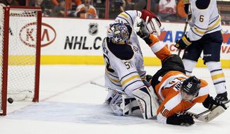 Philadelphia Flyers&#39; Brayden Schenn, right, looks back to see his shot go in the net past Buffalo Sabres goalie Nathan Lieuwen, left, during the second period of an NHL hockey game, Sunday, April 6, 2014, in Philadelphia. (AP Photo/Tom Mihalek)