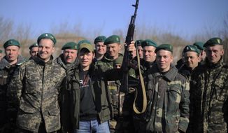 In this photo taken on Saturday, April  5, 2014, Oleh Lyashko, center left, leader of Ukrainian Radical Party and presidential candidate who supported the protests that ousted Russian-leaning president Viktor Yanukovych, poses with Ukrainian soldiers and officers at their camp near Ukraine-Russian border outside Chernihiv, 140km (87 miles) northeast of Kiev, Ukraine. Ukraine&#39;s security service said Saturday it has detained a 15-strong armed gang planning to seize power in an eastern province on the border with Russia. (AP Photo/Osman Karimov)