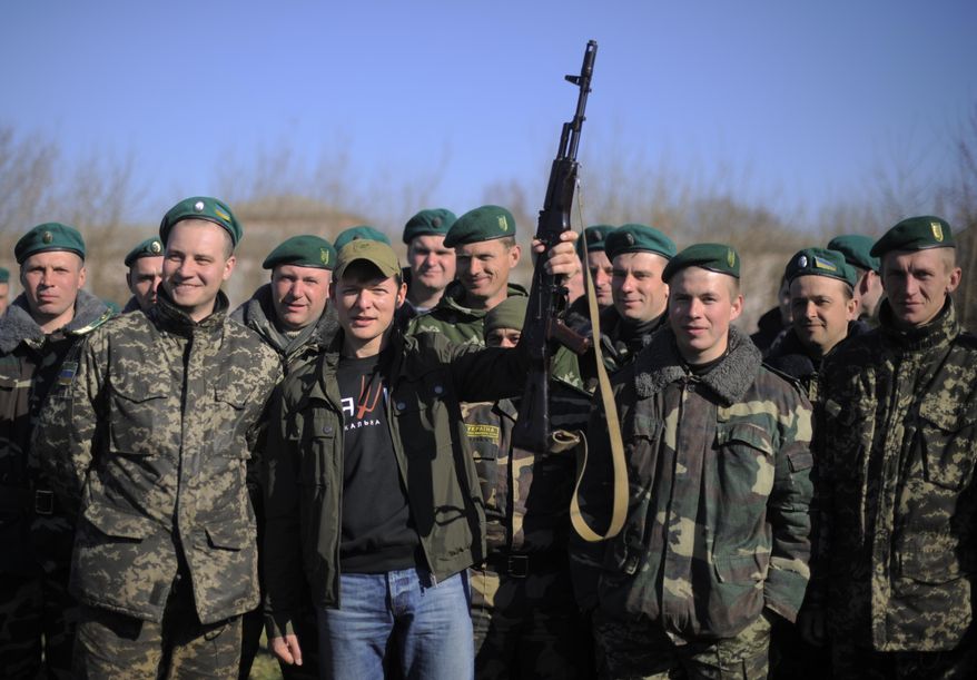 In this photo taken on Saturday, April 5, 2014, Oleh Lyashko, center left, leader of Ukrainian Radical Party and presidential candidate who supported the protests that ousted Russian-leaning president Viktor Yanukovych, poses with Ukrainian soldiers and officers at their camp near Ukraine-Russian border outside Chernihiv, 140km (87 miles) northeast of Kiev, Ukraine. Ukraine's security service said Saturday it has detained a 15-strong armed gang planning to seize power in an eastern province on the border with Russia. (AP Photo/Osman Karimov)