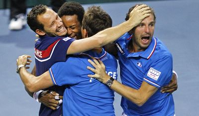 France's Gael Monfils celebrates with teammates Michael llodra, left, and Julien Benneteau, right, after winning his singles match against German player Peter Gojowczyk, in the quarterfinals of the Davis Cup in Nancy, eastern France, Sunday April 6, 2014. France qualifies for the semifinals with a 3-2 score.(AP Photo/Remy de la Mauviniere)
