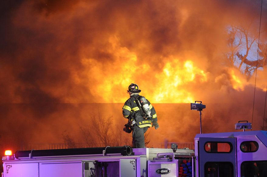 A firefighter works on the scene of a multiple alarm fire at the popular Lakeview Pavilion in Foxboro, Mass., Saturday, April 5, 2014. A wedding was taking place at the time of the fire. (AP Photo/The Sun Chronicle, Mark Stockwell)