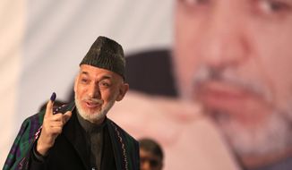 Not going anywhere: Afghan President Hamid Karzai shows indelible ink on his finger before he casts his vote. Zalmay Rassoul has the backing of Mr. Karzai&#39;s clan and political machinery.