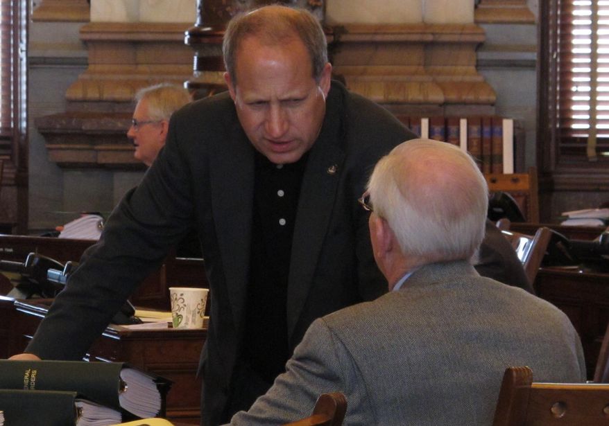 Kansas state Sen. Forrest Knox, left, R- Altoona, confers with Tom Arpke, R- Salina, as senators wait to debate a new school funding plan, Sunday, April 6, 2014, at the Statehouse in Topeka, Kan. The plan boosts aid to poor school districts but eliminates teacher tenure. (AP Photo/John Hanna)