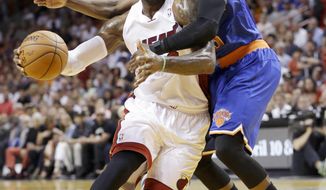 Miami Heat forward LeBron James is fouled by New York Knicks guard Tim Hardaway Jr., right, during the first half of an NBA basketball game, Sunday, April 6, 2014, in Miami. (AP Photo/Wilfredo Lee)