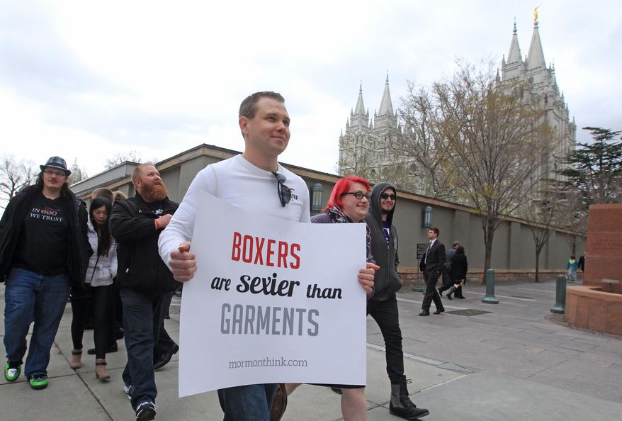 Jared Bowden carries a sign as he marches with Utah atheists and former Mormons as they march around the Salt Lake Temple Square during the Mormon church general conference, Sunday, April 6, 2014, in Salt Lake City. More than 100,000 Latter-day Saints are expected in Salt Lake City this weekend for the church's biannual general conference. Leaders of The Church of Jesus Christ of Latter-day Saints give carefully crafted speeches aimed at providing members with guidance and inspiration in five sessions that span Saturday and Sunday. They also make announcements about church statistics, new temples or initiatives. In addition to those filling up the 21,000-seat conference center during the sessions, thousands more listen or watch around the world in 95 languages on television, radio, satellite and Internet broadcasts. (AP Photo/Rick Bowmer)