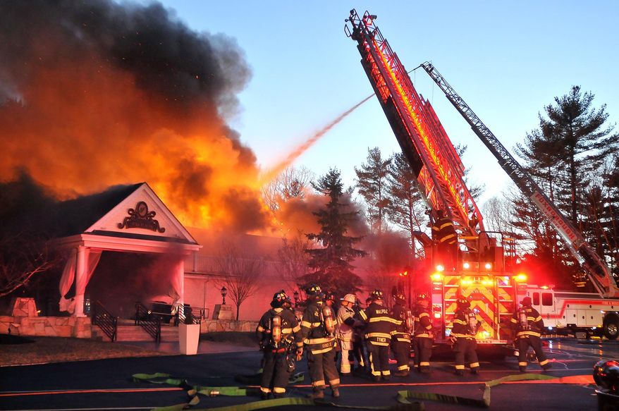 Firefighters respond to a multiple alarm fire at the popular Lakeview Pavilion in Foxboro, Mass., Saturday, April 5, 2014. A wedding was taking place at the time of the fire. (AP Photo/The Sun Chronicle, Mark Stockwell)