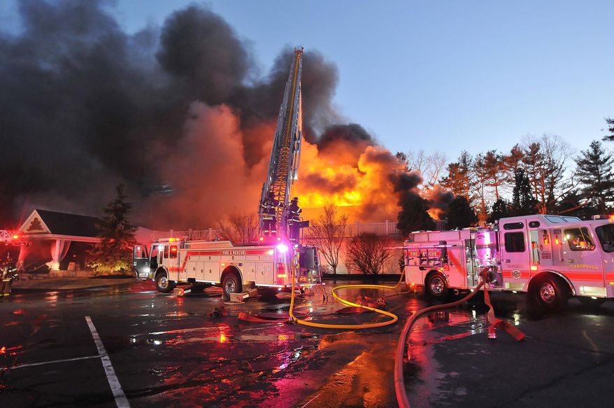 Firefighters respond to a multiple alarm fire at the popular Lakeview Pavilion in Foxboro, Mass., Saturday, April 5, 2014. A wedding was taking place at the time of the fire. (AP Photo/The Sun Chronicle, Mark Stockwell)